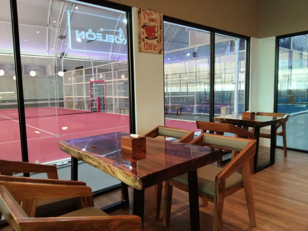 Café tables looking onto the pink court